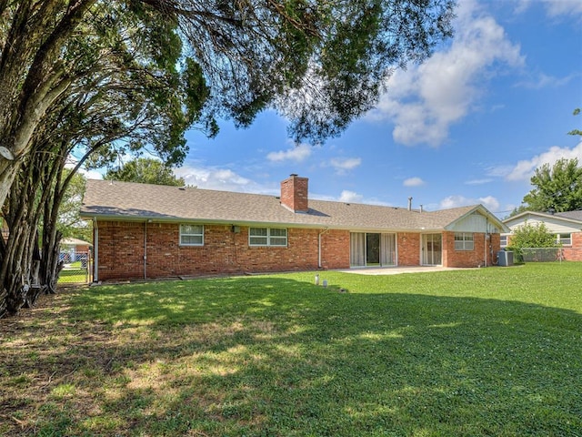 4325 NW 44th St, Oklahoma City, OK 73112 - back of property with a chimney, a patio, and brick siding