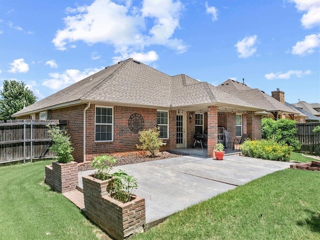 1204 NW 190th Pl, Edmond, OK 73012 - rear view of house with roof with shingles, brick siding, and a patio area