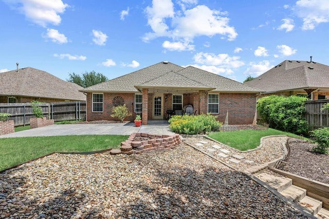 1204 NW 190th Pl, Edmond, OK 73012 - back of property with a patio, a fenced backyard, brick siding, and a shingled roof
