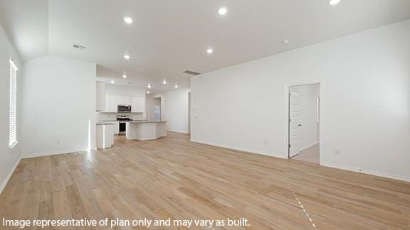 10200 NW 28th Ter, Yukon, OK 73099 - unfurnished living room with light wood-style flooring, recessed lighting, and lofted ceiling