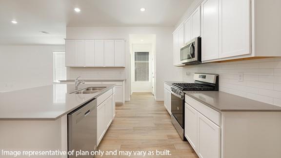 10200 NW 28th Ter, Yukon, OK 73099 - kitchen with stainless steel appliances, decorative backsplash, recessed lighting, light wood-style floors, and white cabinets