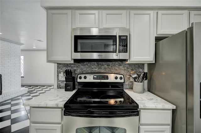 4400 Hemingway Dr Unit 259, Oklahoma City, OK 73118 - kitchen featuring stainless steel appliances, backsplash, light stone countertops, and white cabinetry