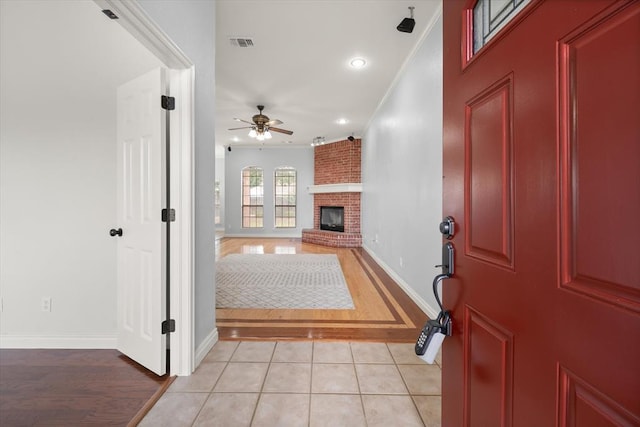 541 SW 154th Ct, Oklahoma City, OK 73170 - foyer entrance featuring ornamental molding, a fireplace, a ceiling fan, light wood finished floors, and recessed lighting