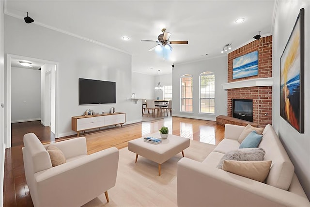 541 SW 154th Ct, Oklahoma City, OK 73170 - living room featuring a ceiling fan, crown molding, recessed lighting, light wood-style flooring, and a brick fireplace