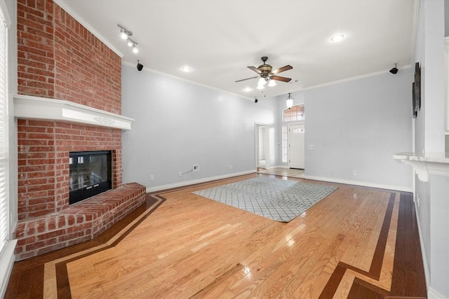 541 SW 154th Ct, Oklahoma City, OK 73170 - unfurnished living room featuring ceiling fan, a fireplace, ornamental molding, and wood finished floors