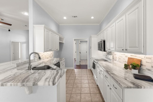 541 SW 154th Ct, Oklahoma City, OK 73170 - kitchen with white electric range oven, a peninsula, ornamental molding, tasteful backsplash, and white cabinetry