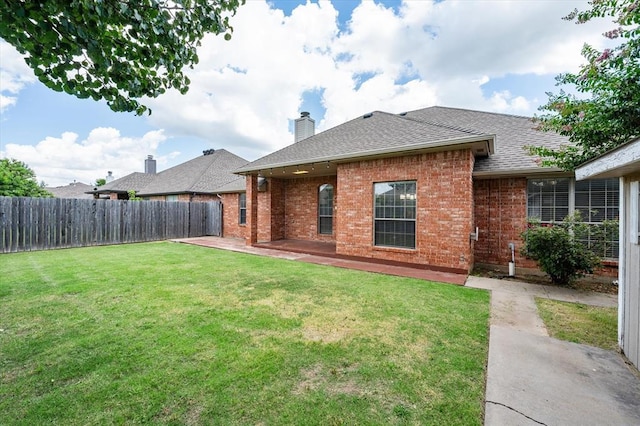 541 SW 154th Ct, Oklahoma City, OK 73170 - rear view of house with brick siding, a fenced backyard, roof with shingles, a chimney, and a patio area