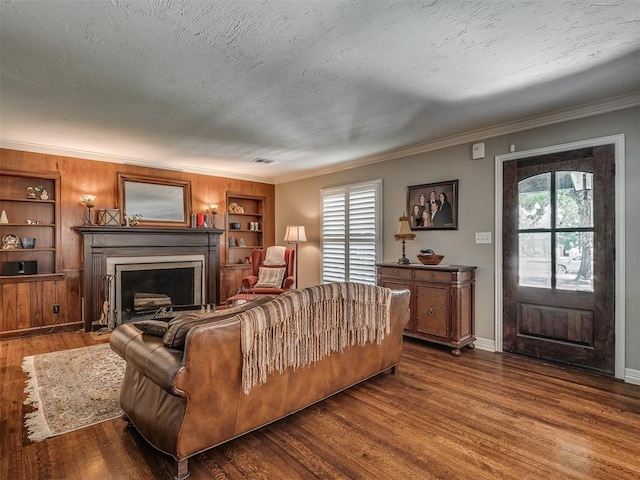 1718 Guilford Ln, Oklahoma City, OK 73120 - living room featuring dark wood finished floors, ornamental molding, a fireplace with flush hearth, and built in features