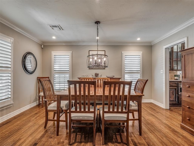 1718 Guilford Ln, Oklahoma City, OK 73120 - dining room with light wood-style floors, a chandelier, healthy amount of natural light, ornamental molding, and recessed lighting