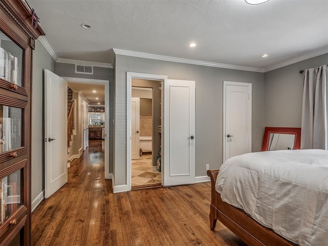 1718 Guilford Ln, Oklahoma City, OK 73120 - bedroom featuring dark wood-style flooring, crown molding, recessed lighting, and connected bathroom