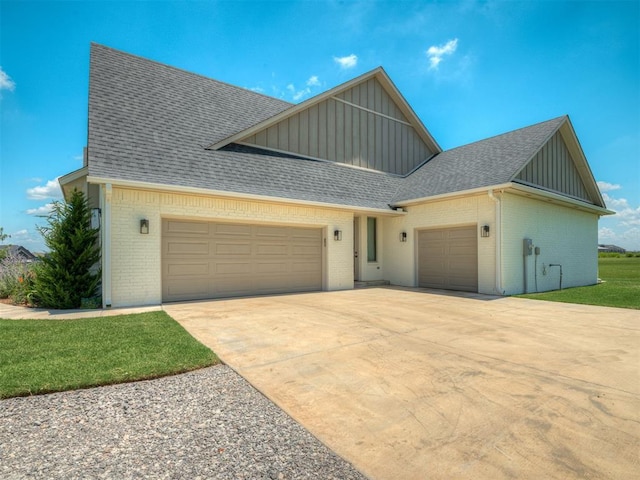 7290 NE Hawk Dr, Piedmont, OK 73078 - view of front facade featuring board and batten siding, an attached garage, brick siding, and roof with shingles