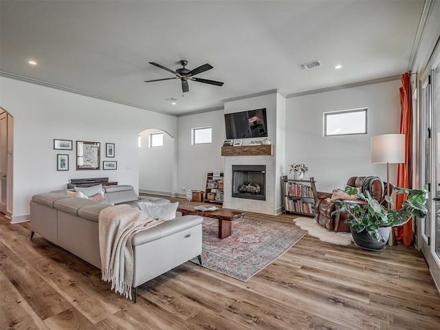 7290 NE Hawk Dr, Piedmont, OK 73078 - living area featuring arched walkways, ornamental molding, plenty of natural light, a ceiling fan, and a fireplace