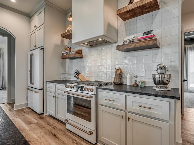 7290 NE Hawk Dr, Piedmont, OK 73078 - kitchen with white gas range oven, open shelves, high end refrigerator, light wood-type flooring, and premium range hood