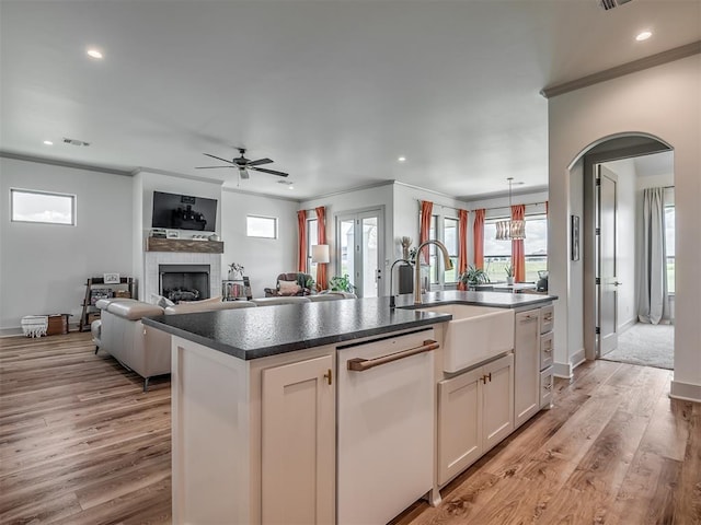 7290 NE Hawk Dr, Piedmont, OK 73078 - kitchen with white dishwasher, ornamental molding, dark countertops, ceiling fan, and a center island with sink