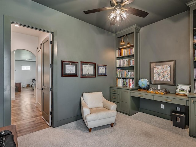 7290 NE Hawk Dr, Piedmont, OK 73078 - living area featuring arched walkways, ceiling fan, built in desk, and built in features