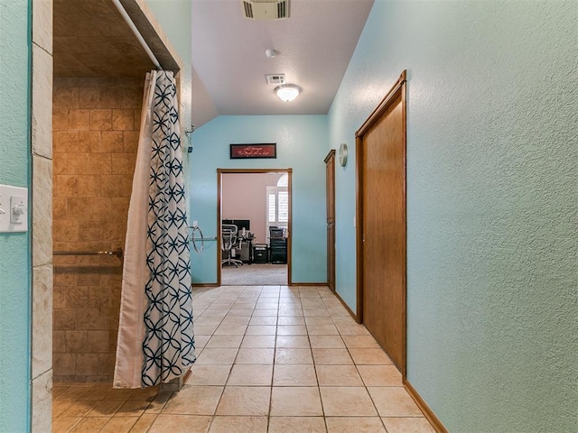 4821 SE 52nd St, Oklahoma City, OK 73135 - hall featuring a textured wall, light tile patterned flooring, and lofted ceiling