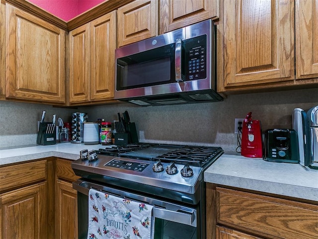 4821 SE 52nd St, Oklahoma City, OK 73135 - kitchen featuring stainless steel appliances, brown cabinetry, and light countertops