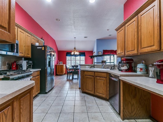 4821 SE 52nd St, Oklahoma City, OK 73135 - kitchen featuring appliances with stainless steel finishes, brown cabinets, light countertops, lofted ceiling, and a textured ceiling