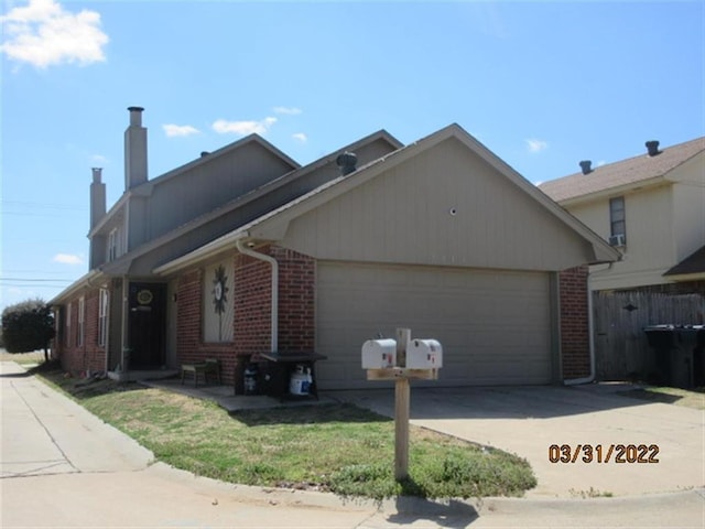 7314 NW 94th St, Oklahoma City, OK 73162 - view of front of house featuring brick siding, concrete driveway, a garage, and a chimney