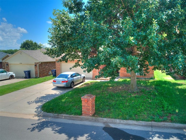 12320 NW 4th St, Yukon, OK 73099 - view of front of house featuring brick siding, driveway, a garage, and a front yard