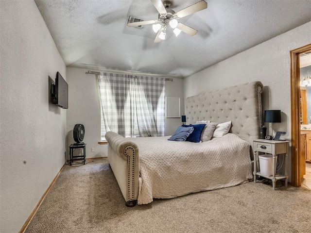 12320 NW 4th St, Yukon, OK 73099 - carpeted bedroom with a textured wall, connected bathroom, and a ceiling fan