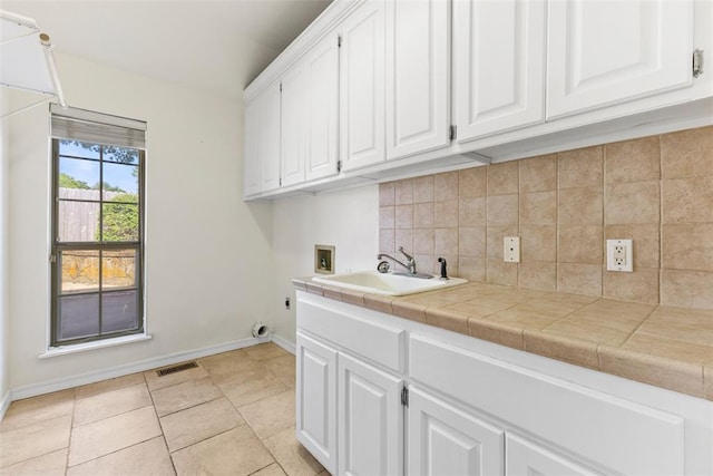 1505 S Augusta Dr, Ada, OK 74820 - laundry area with cabinet space, hookup for a washing machine, light tile patterned flooring, and electric dryer hookup