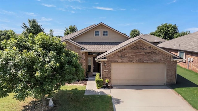 2308 SW 135th St, Oklahoma City, OK 73170 - view of front of home with a garage, concrete driveway, brick siding, a front lawn, and roof with shingles