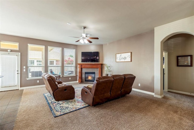 2308 SW 135th St, Oklahoma City, OK 73170 - carpeted living area featuring ceiling fan, a tiled fireplace, and arched walkways