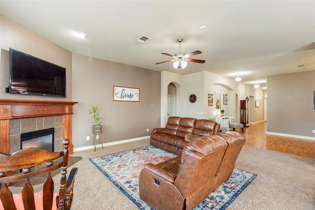 2308 SW 135th St, Oklahoma City, OK 73170 - carpeted living area with arched walkways, ceiling fan, and a tiled fireplace