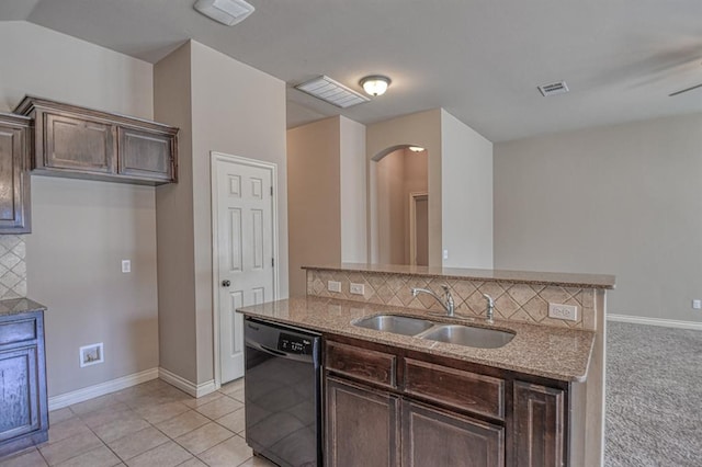 9544 SW 27th St, Oklahoma City, OK 73128 - kitchen with black dishwasher, backsplash, light stone counters, arched walkways, and dark brown cabinets