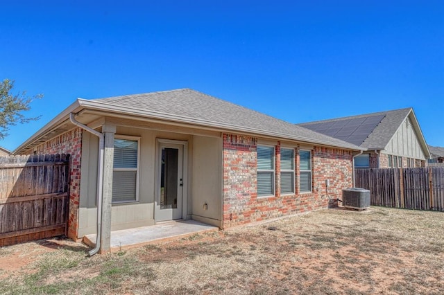 9544 SW 27th St, Oklahoma City, OK 73128 - back of house featuring a shingled roof, a fenced backyard, and brick siding