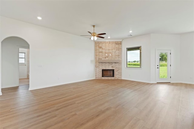 29744 Jade St, Cashion, OK 73016 - unfurnished living room with a ceiling fan, light wood-style flooring, recessed lighting, arched walkways, and a fireplace