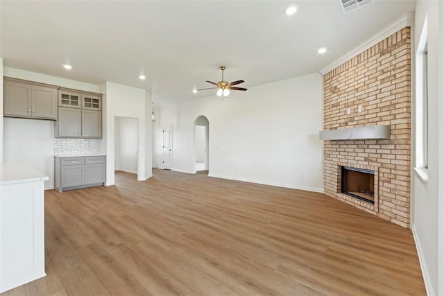 29744 Jade St, Cashion, OK 73016 - unfurnished living room with ceiling fan, arched walkways, a fireplace, light wood-type flooring, and recessed lighting