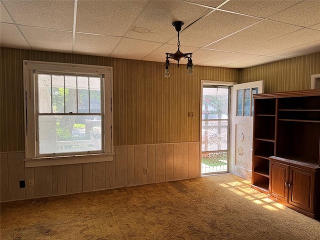 415 N Wentz St, Guthrie, OK 73044 - unfurnished dining area featuring carpet floors, plenty of natural light, wooden walls, and a drop ceiling