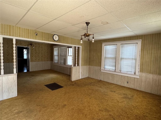 415 N Wentz St, Guthrie, OK 73044 - spare room featuring carpet, a paneled ceiling, healthy amount of natural light, wallpapered walls, and wainscoting