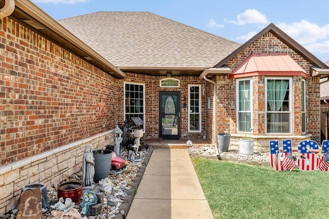 13117 SW 2nd Ter, Yukon, OK 73099 - property entrance with a shingled roof, brick siding, and a lawn