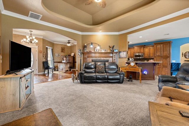 13117 SW 2nd Ter, Yukon, OK 73099 - living area with a ceiling fan, light colored carpet, a chandelier, a raised ceiling, and ornamental molding