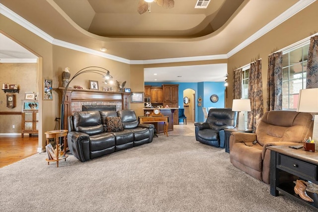 13117 SW 2nd Ter, Yukon, OK 73099 - living room with light carpet, a tray ceiling, a ceiling fan, and ornamental molding
