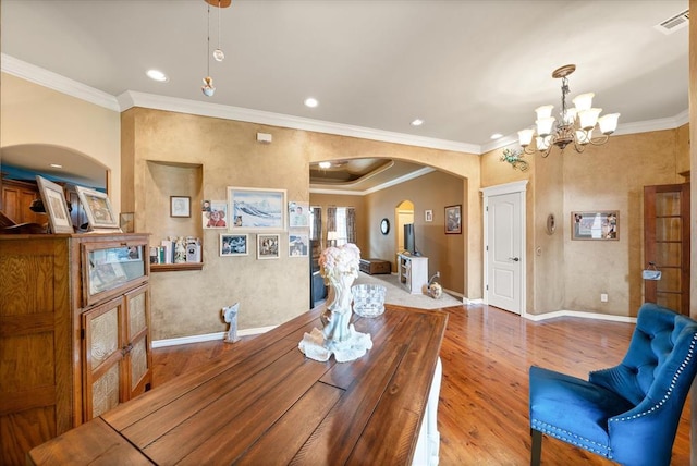 13117 SW 2nd Ter, Yukon, OK 73099 - dining area featuring arched walkways, a chandelier, wood finished floors, crown molding, and recessed lighting