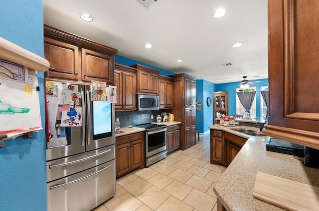 13117 SW 2nd Ter, Yukon, OK 73099 - kitchen featuring stainless steel appliances, tasteful backsplash, light tile patterned flooring, recessed lighting, and a ceiling fan