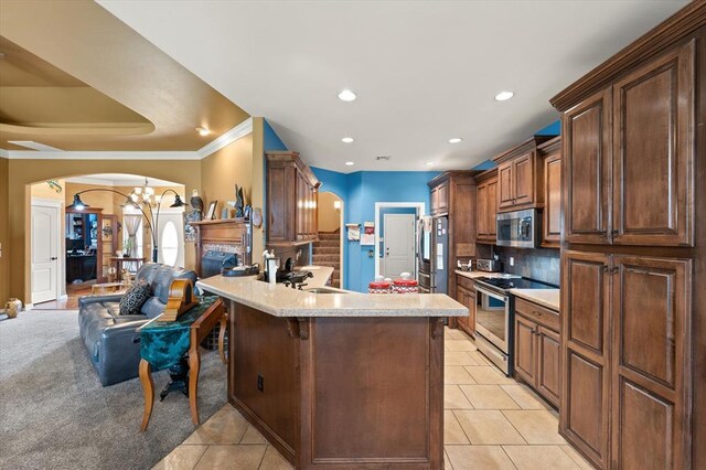13117 SW 2nd Ter, Yukon, OK 73099 - kitchen featuring stainless steel appliances, arched walkways, light countertops, a chandelier, and ornamental molding