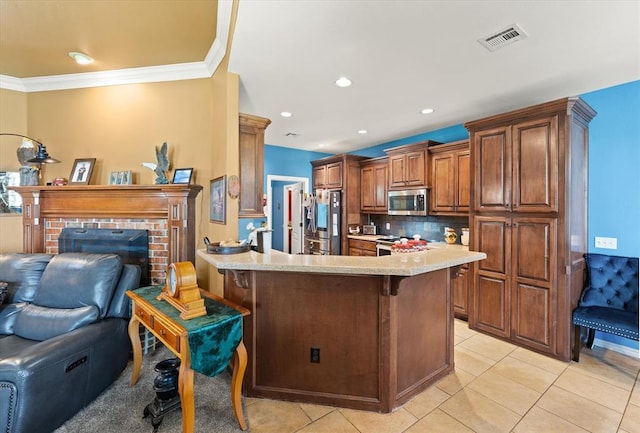 13117 SW 2nd Ter, Yukon, OK 73099 - kitchen with appliances with stainless steel finishes, open floor plan, a breakfast bar, a peninsula, and backsplash