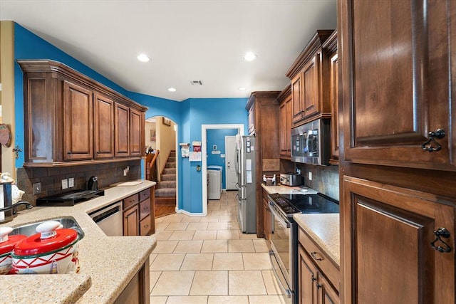 13117 SW 2nd Ter, Yukon, OK 73099 - kitchen with appliances with stainless steel finishes, arched walkways, backsplash, light tile patterned floors, and recessed lighting