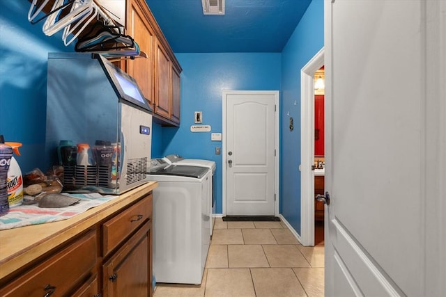 13117 SW 2nd Ter, Yukon, OK 73099 - washroom featuring washer and dryer, cabinet space, and light tile patterned floors