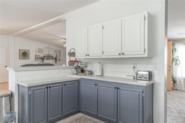 1300 Hutton Rd, Marlow, OK 73055 - kitchen with a peninsula, light countertops, a ceiling fan, and white cabinetry