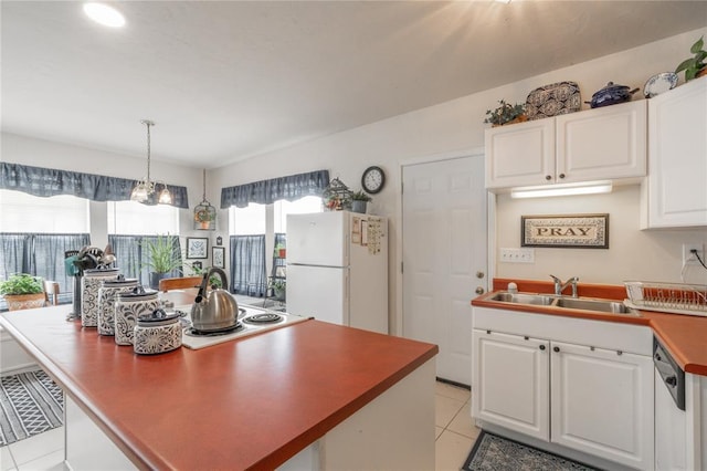 1300 Hutton Rd, Marlow, OK 73055 - kitchen featuring freestanding refrigerator, light tile patterned floors, white cabinetry, a center island, and hanging light fixtures