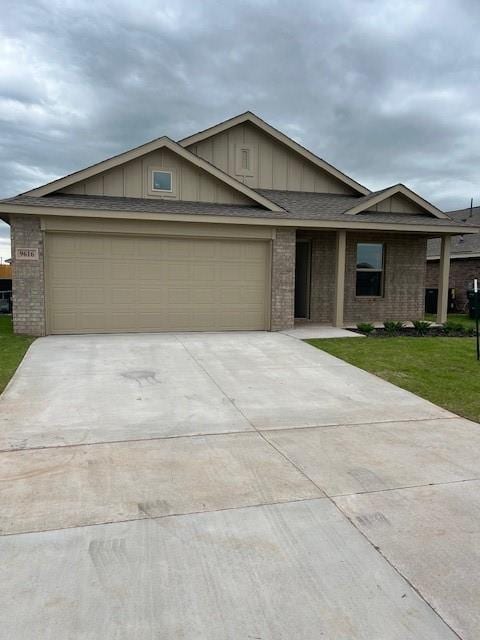 9616 NW 125th Ter, Yukon, OK 73099 - view of front of house featuring brick siding, driveway, board and batten siding, an attached garage, and a front yard