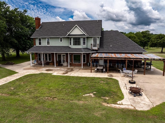 105074 N 3770th Rd, Okemah, OK 74859 - back of property featuring a fire pit, a patio area, a yard, and a shingled roof