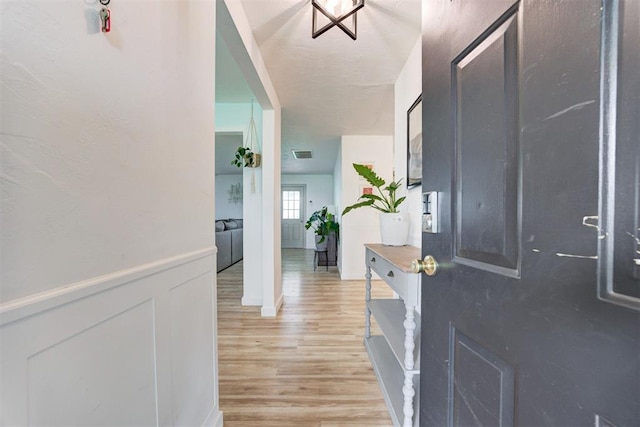 2401 Big Cedar Ave, Edmond, OK 73012 - foyer with light wood finished floors and a wainscoted wall