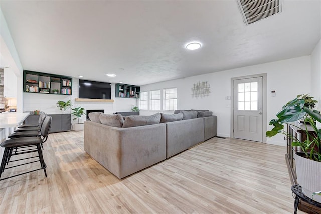 2401 Big Cedar Ave, Edmond, OK 73012 - living area featuring light wood-style flooring, a fireplace, plenty of natural light, and recessed lighting